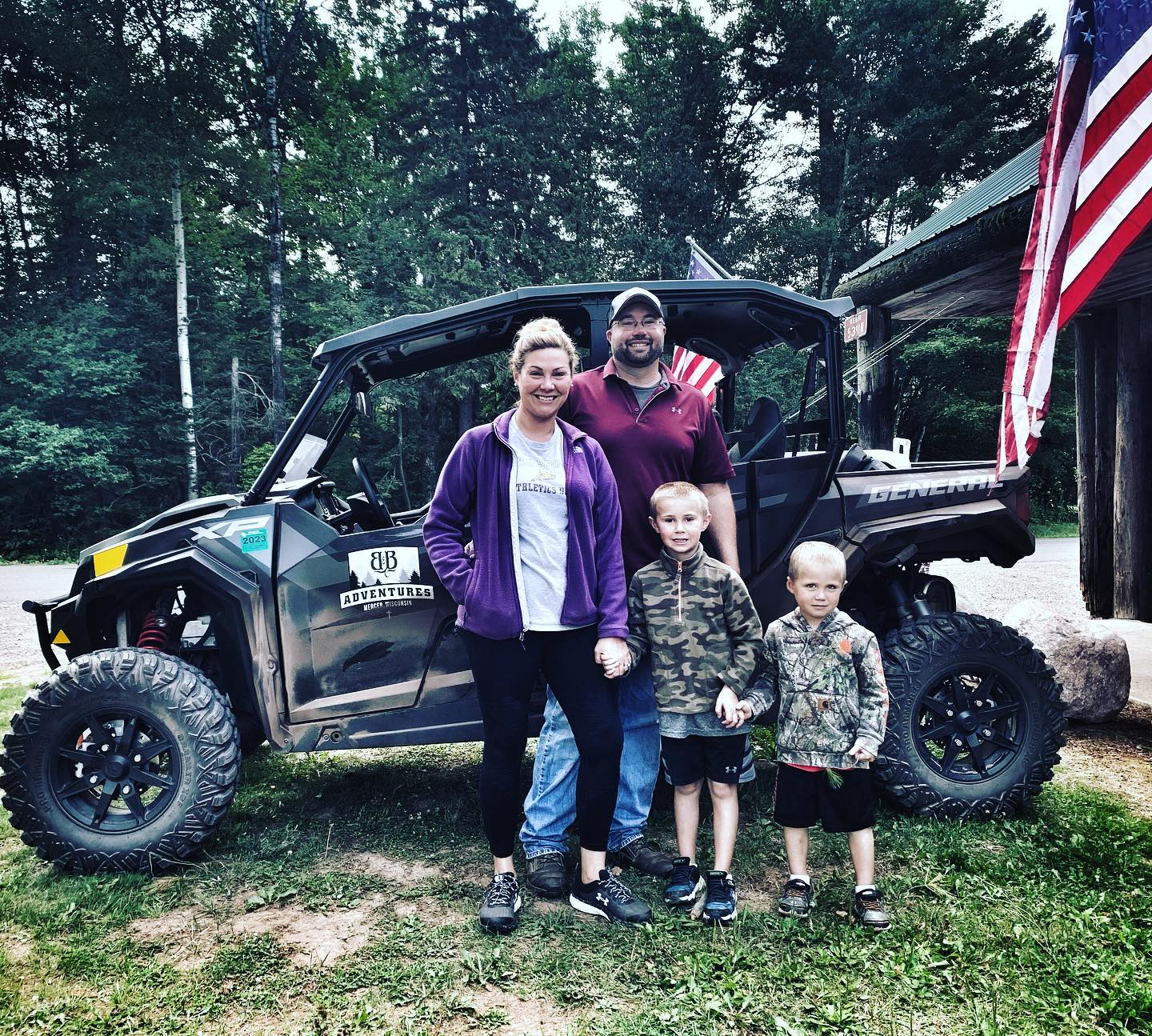 a group of people standing in front of a car posing for the camera