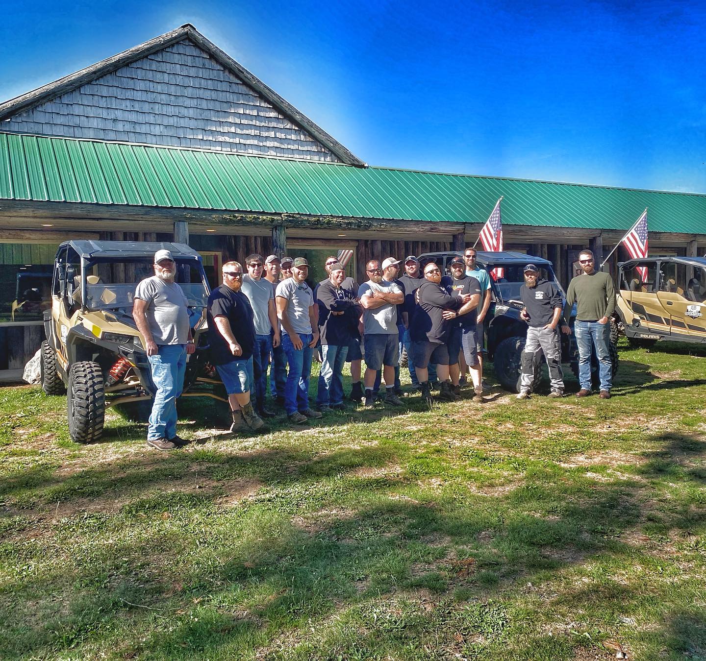 a group of people standing in front of a green field